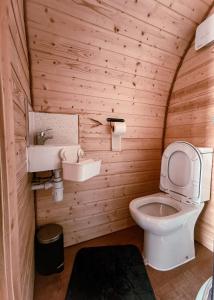 a wooden bathroom with a toilet and a sink at Crabmill Glamping with hot tub in Bewdley