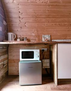 a kitchen with a counter with a microwave and a dishwasher at Crabmill Glamping with hot tub in Bewdley