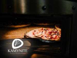 Eine Pizza wird in einem Ofen gekocht in der Unterkunft Хотел Камъните in Burgas City