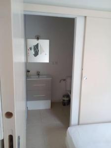a white bathroom with a sink and a toilet at Single storey 40m² bordering pine forest and spa in Noves