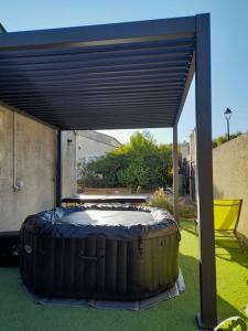 un gran barril sentado bajo una cubierta en un patio en Single storey 40m² bordering pine forest and spa en Noves