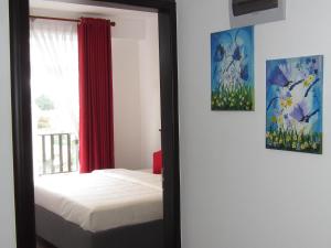 a mirror in a bedroom with a bed and a window at Chanya Luxury Apartment, S 31, Lake View Residencies in Nuwara Eliya