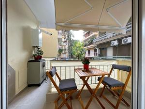 einen kleinen Balkon mit einem Tisch und 2 Stühlen in der Unterkunft Purple studio in Thessaloniki