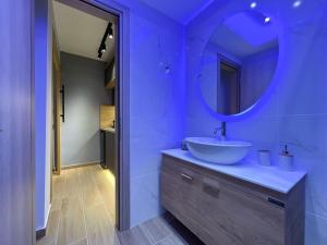 ein blaues Badezimmer mit einem Waschbecken und einem Spiegel in der Unterkunft Purple studio in Thessaloniki