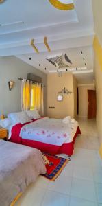 a bedroom with two beds and a ceiling at Kasbah Restaurant Amazir in Tinerhir