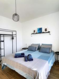 a bedroom with a large bed with blue pillows on it at Azur Arts Lanzarote Lofts in Tinajo