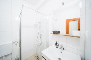 baño blanco con ducha y lavamanos en Pansion Lipa en Blato