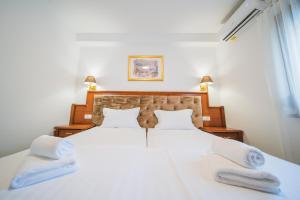 a bedroom with a large white bed with towels on it at Pansion Lipa in Blato