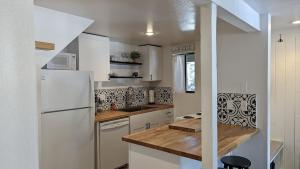 a kitchen with white appliances and a wooden counter top at Cozy condo walking distance to village and gondola w/ pool/ jacuzzi sleeps 4. in Mammoth Lakes