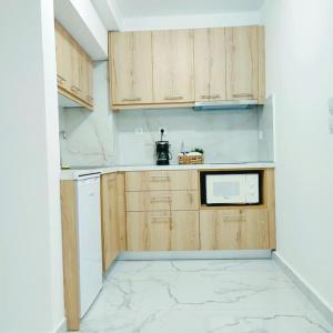 uma cozinha com armários de madeira e um micro-ondas em Dream Apartment Ioannina em Ioannina