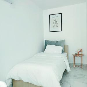 um quarto com uma cama branca e uma fotografia na parede em Dream Apartment Ioannina em Ioannina