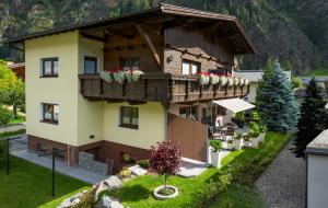 ein Haus mit einem Balkon mit Blumen darauf in der Unterkunft Appartements Kuprian in Längenfeld