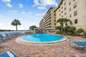 a swimming pool with chairs and a building at Bayshore Yacht & Tennis 216 in Clearwater Beach