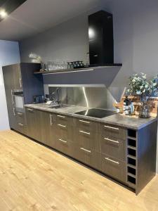 uma cozinha com armários de aço inoxidável e um lavatório em Lovely apartment with hot tub access em Akureyri