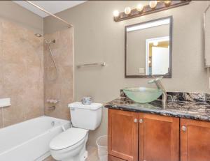 a bathroom with a toilet and a sink and a tub at Houston/Sugar Land Area 2 BDR- Bellaire in Houston