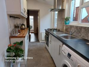 a kitchen with a sink and a stove at Salisbury House-Huku Kwetu Spacious 4 Bedrooms House- Sleeps 6 - Luton Town Centre in Luton