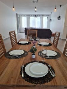 una mesa de comedor con platos blancos. en MoonLight, en Pointe aux Piments