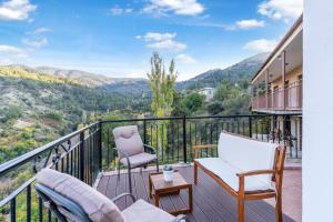 a balcony with chairs and a view of the mountains at House Eufrosyne in Moutoullas