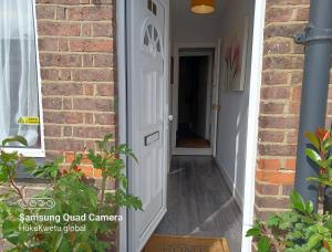 a white door leading into a brick house at Salisbury House-Huku Kwetu Spacious 4 Bedrooms House- Sleeps 6 - Luton Town Centre in Luton