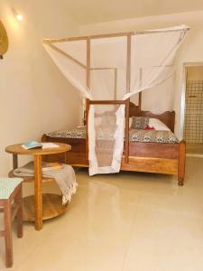 a bedroom with two bunk beds and a table at Ladha ya Zanzibar Boutique Guesthouse in Jambiani