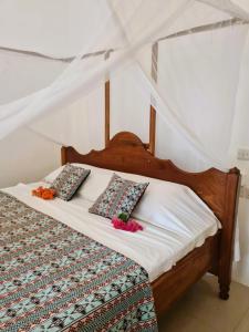 Una cama con dos almohadas encima. en Ladha ya Zanzibar Boutique Guesthouse, en Jambiani