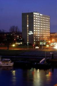 a large building in a city at night at Hotel Am Terrassenufer in Dresden