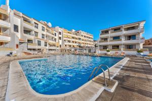 a swimming pool in front of some apartment buildings at LosCristianos Luxury AirCon Sunny Aptm Sea View in Arona
