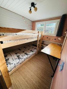 a bedroom with two bunk beds and a window at Péniche Dondon - Gîte cocooning sur Canal du midi in Avignonet-de-Lauragais