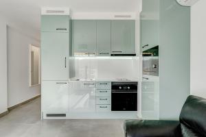 a kitchen with white cabinets and a black oven at LosCristianos Luxury AirCon Sunny Aptm Sea View in Arona
