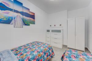 a white bedroom with a bed and a dresser at LosCristianos Luxury AirCon Sunny Aptm Sea View in Arona +7 photos