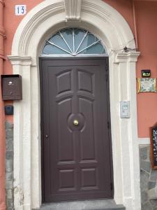 a black door in a building with an arch at Cami s holidays home in Catania