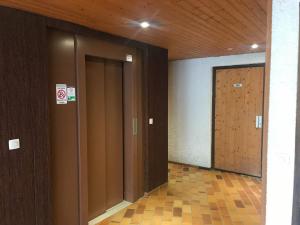 a hallway with two elevators and a wooden door at Studio Samoëns, 1 pièce, 4 personnes - FR-1-629-117 in Samoëns