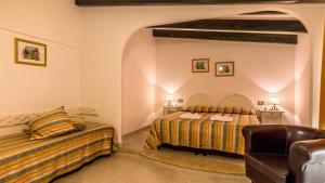 カラゼッタにあるHotel Cala Di Setaのベッド2台とソファが備わるホテルルームです。