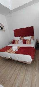 a bedroom with a large bed with a red headboard at Encantador estudio en Alameda de Hércules in Seville