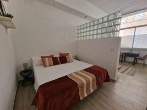 a bedroom with a large bed in a white room at Encantador estudio en Alameda de Hércules in Seville