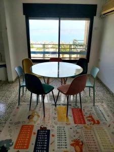 a table and chairs in a room with a window at turtle guesthouse- tiberias in Tiberias