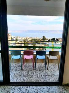 a group of chairs sitting on a balcony with a view at turtle guesthouse- tiberias in Tiberias