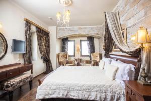 1 dormitorio con 1 cama grande y pared de piedra en Alseides Boutique Hotel en Elatochori