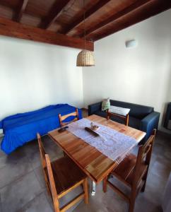 comedor con mesa de madera y sofá azul en Lo de Sil en Santa Teresita