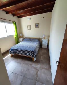 1 dormitorio con 1 cama, 2 mesas y una ventana en Lo de Sil en Santa Teresita