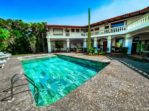 a swimming pool in front of a house at Canal Grande Lodge in Piedades