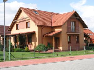 a house with a red roof on a street at Pension Iveta in Liptovský Mikuláš