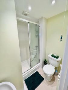 a bathroom with a toilet and a glass shower at Conservation Area - between Bristol and Bath, both 9 mins by train! in Keynsham