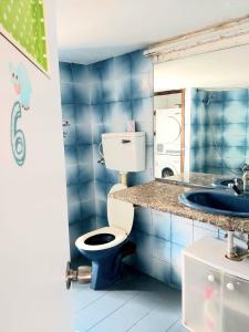 een blauw betegelde badkamer met een toilet en een wastafel bij turtle guesthouse- tiberias in Tiberias