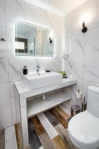 een witte badkamer met een wastafel en een toilet bij Ermioni Sea View Hotel in Limenaria