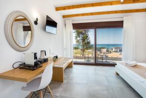 a bedroom with a desk and a bed with a mirror at Ermioni Sea View Hotel in Limenaria