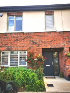 a brick house with a black door and flowers at Cozy room in Lucan in Lucan