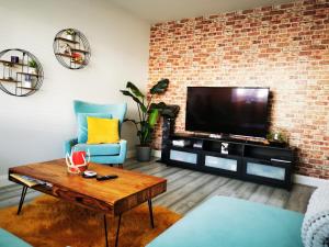 a living room with a television and a brick wall at Cozy room in Lucan in Lucan
