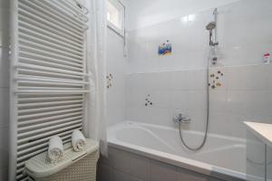 Un baño blanco con bañera y ducha. en Santos 1214 Apartment, en Budapest 22 fotos más
