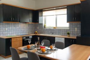 una cocina con una mesa con dos platos de naranjas. en Chania City Villa, en Mourniaí